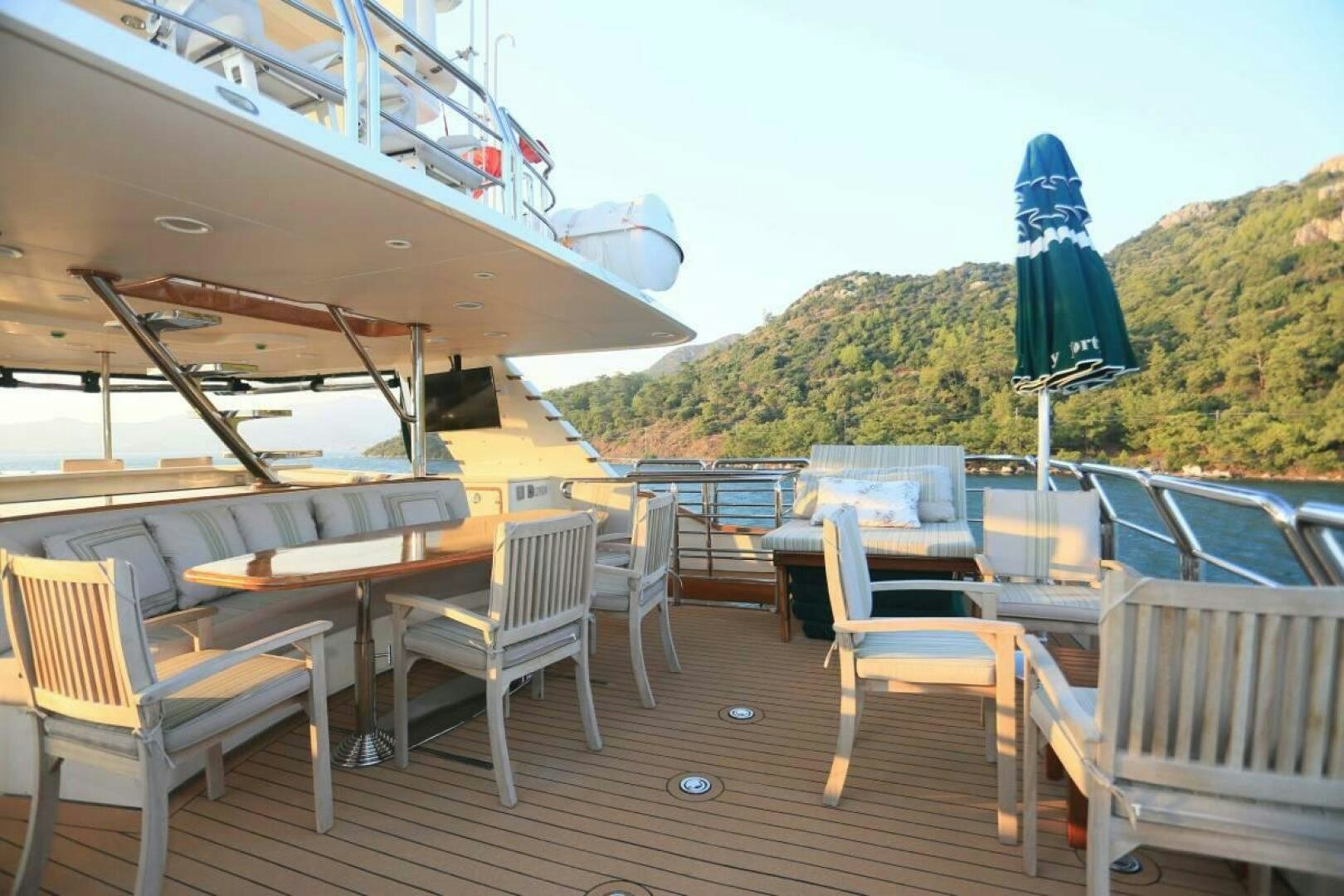 a deck with tables and chairs on it aboard FORTY LOVE Yacht for Sale