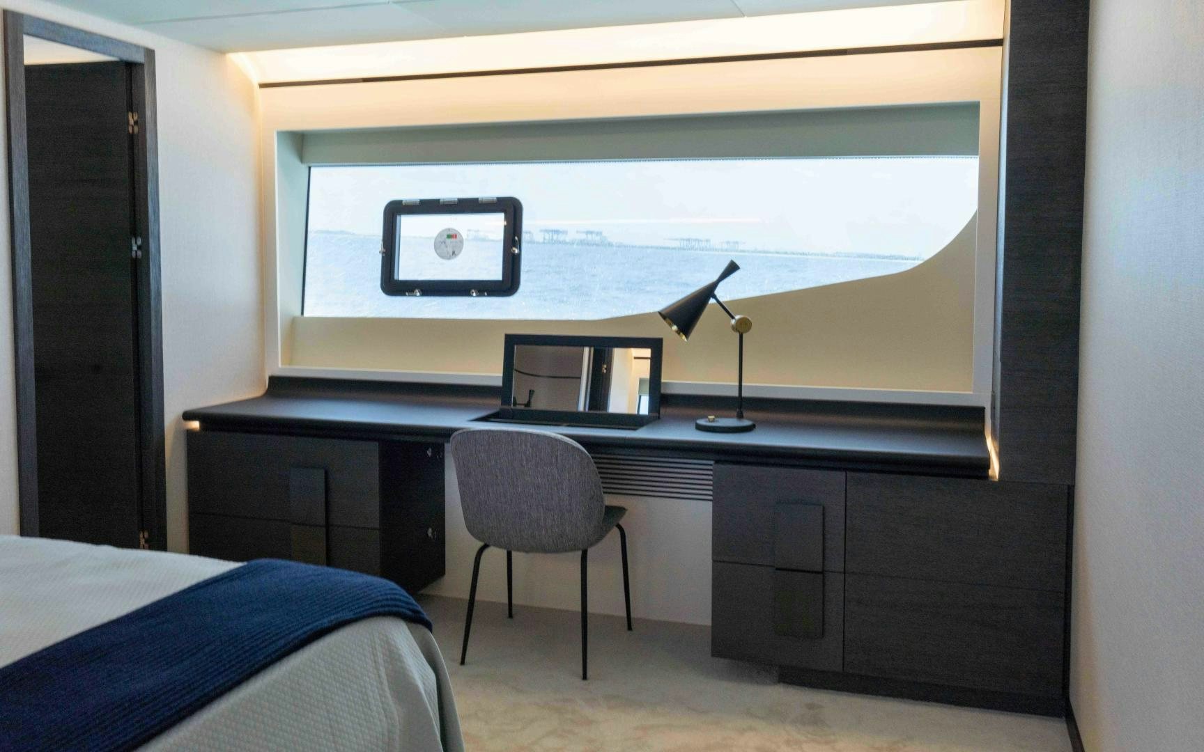 a desk with a laptop and a window aboard C3 Yacht for Sale