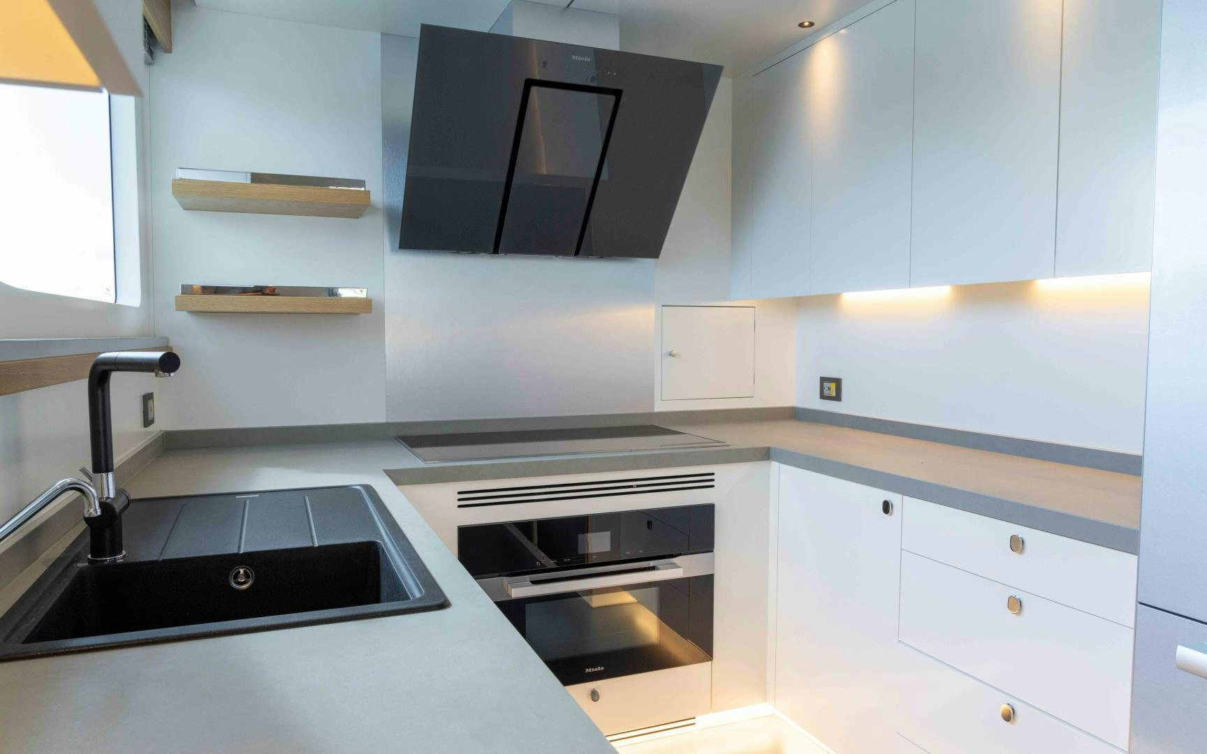 a kitchen with black appliances aboard C3 Yacht for Sale