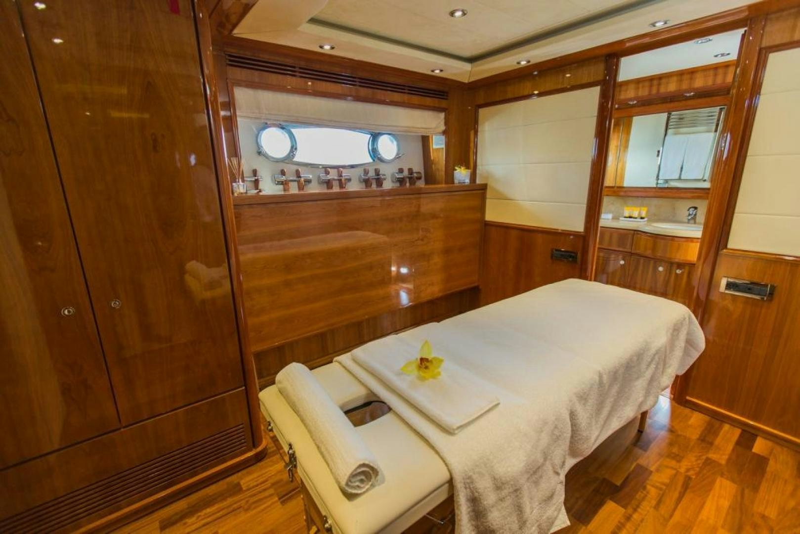 a room with a bed and a chair aboard CHAMPAGNE & CAVIAR Yacht for Sale