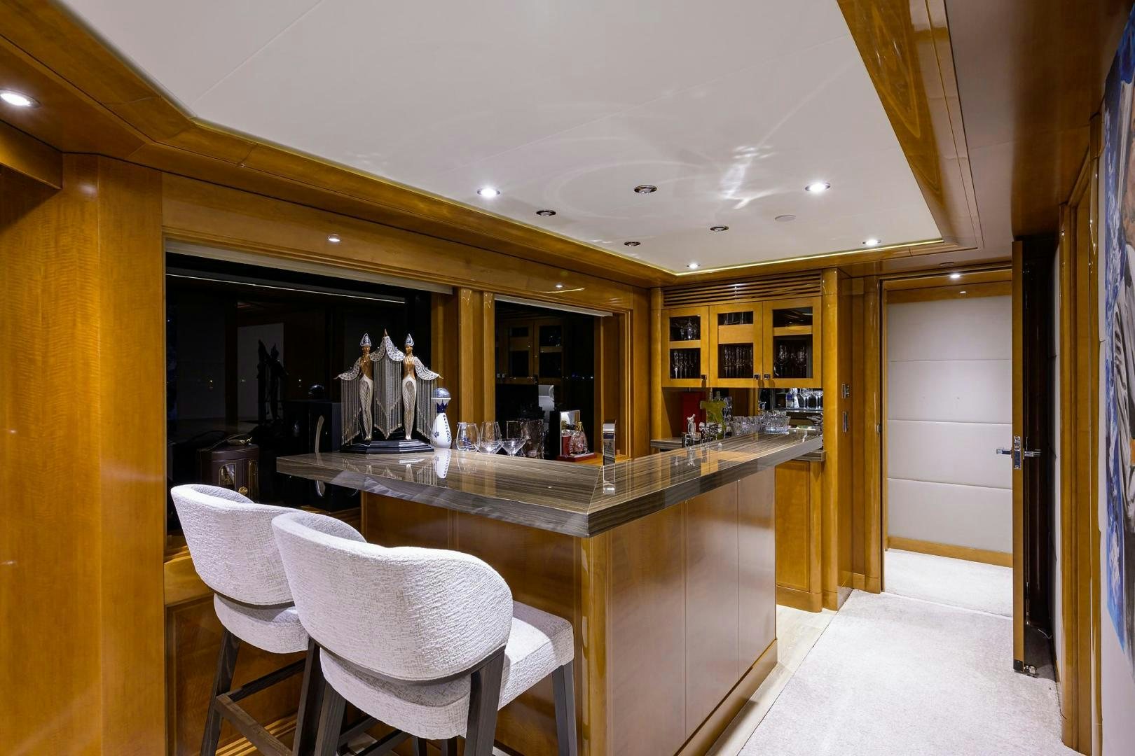 a kitchen with a bar and chairs aboard SEANASH Yacht for Sale