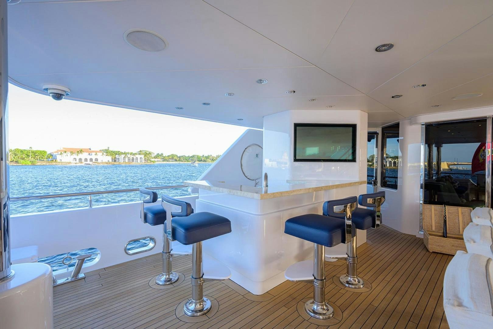 a room with a large window and a table with chairs and a television aboard SEANASH Yacht for Sale
