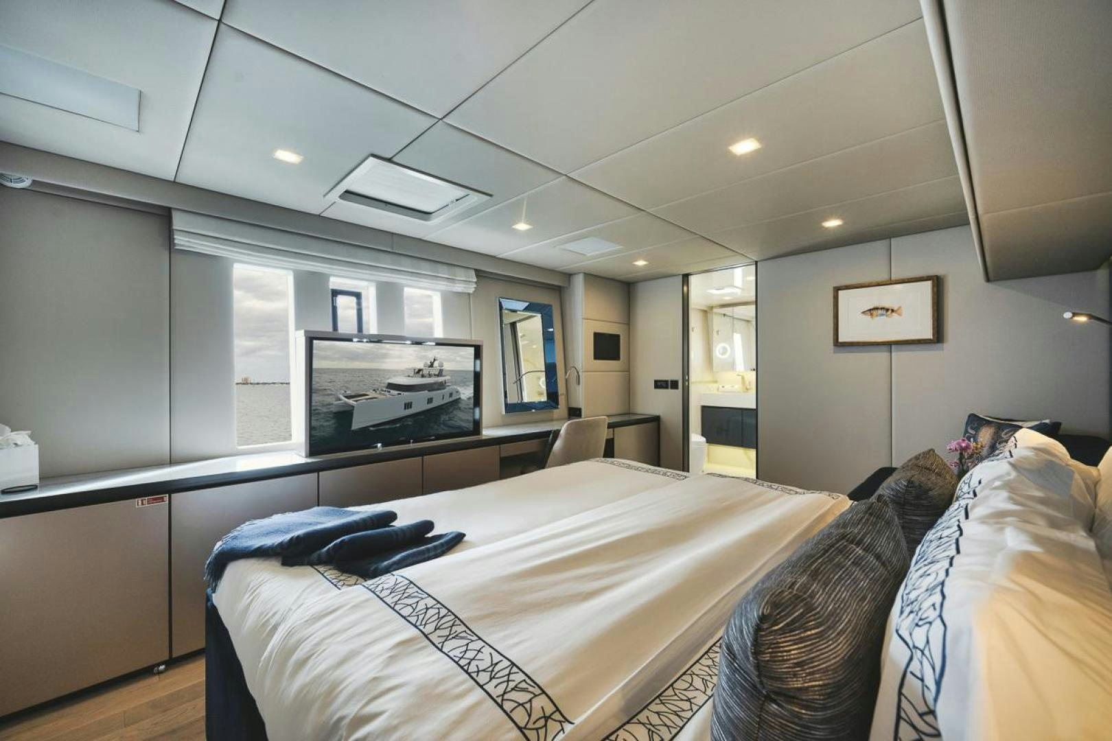 a bedroom with a bed and a tv on the wall aboard SANDY II Yacht for Sale