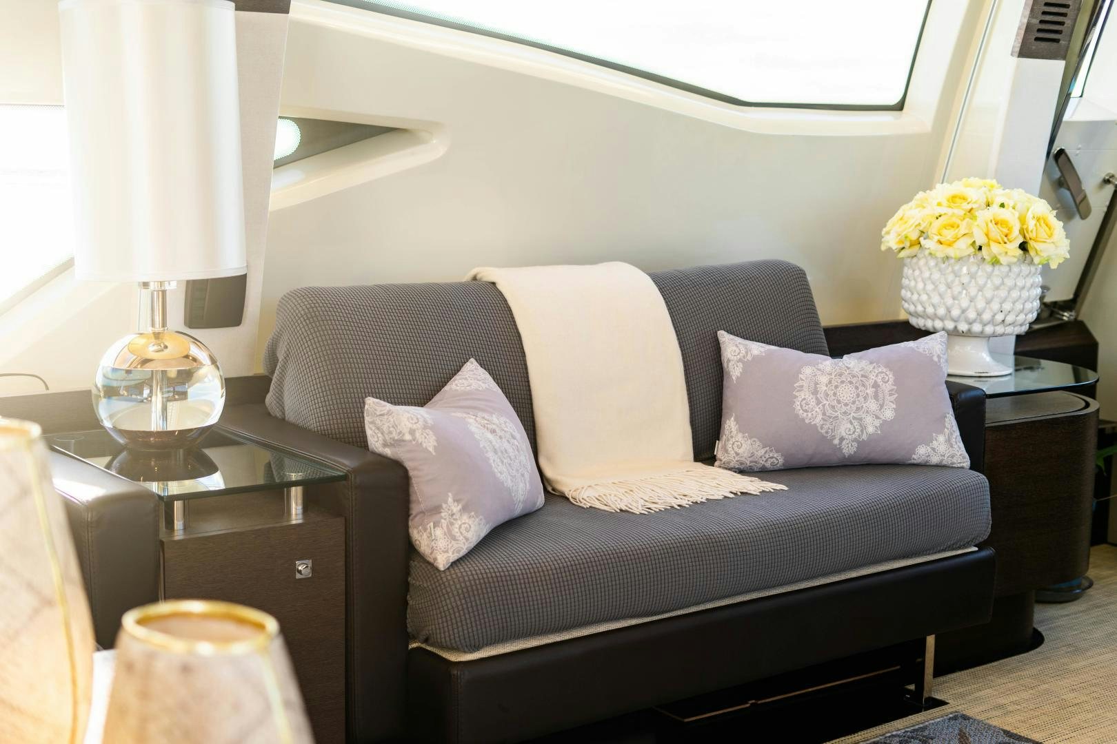 a couch with pillows and flowers aboard PLANE II SEA Yacht for Sale