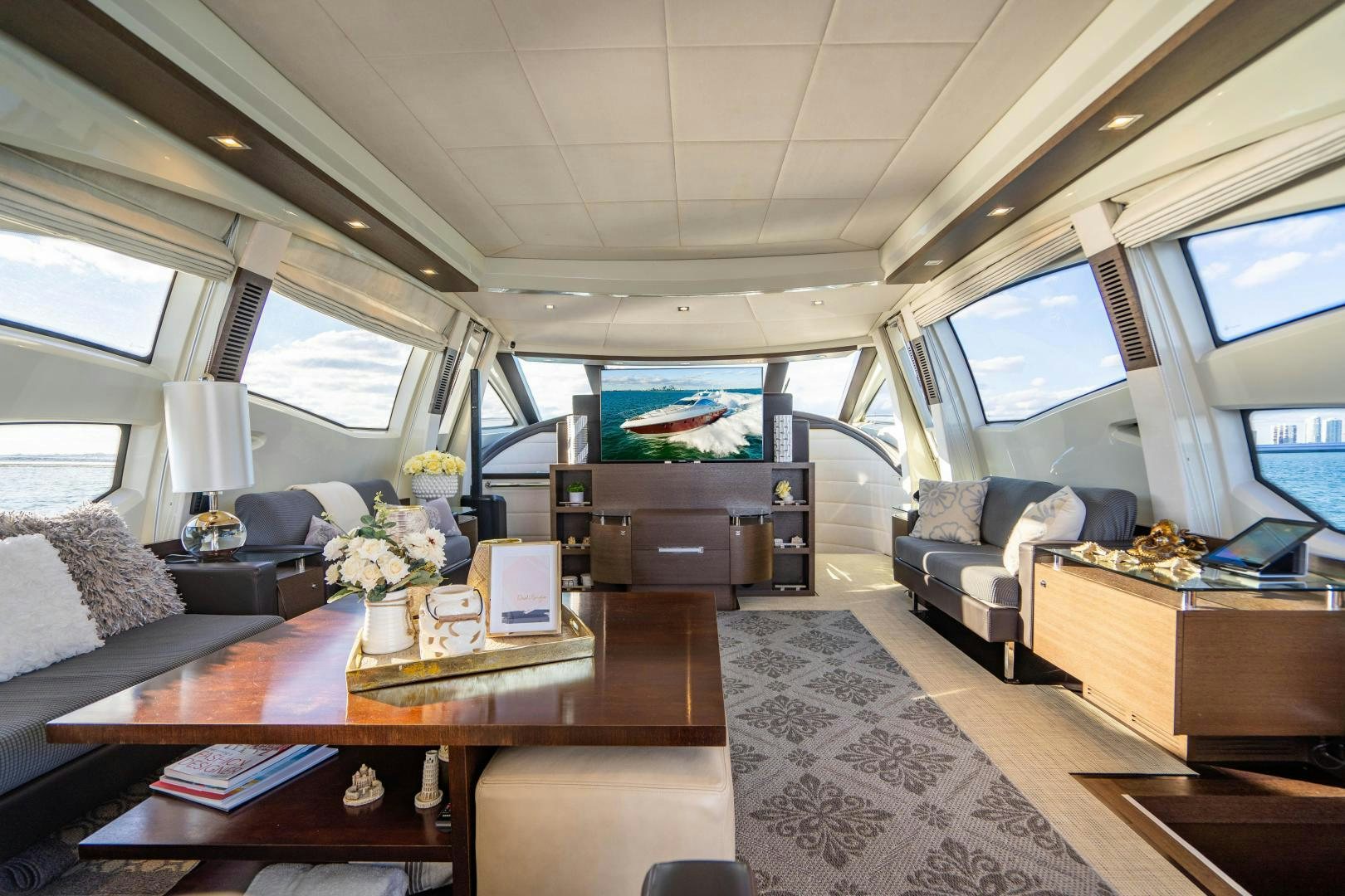 a room with a couch and a table with a laptop on it aboard PLANE II SEA Yacht for Sale