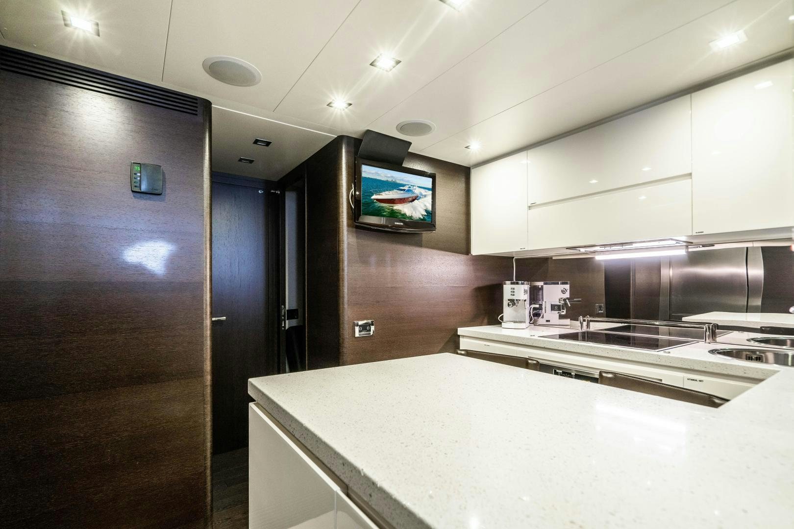 a kitchen with a tv on the wall aboard PLANE II SEA Yacht for Sale