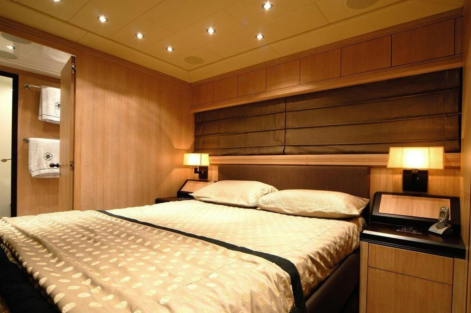 a hotel room with a bed and lamp aboard ARES Yacht for Sale