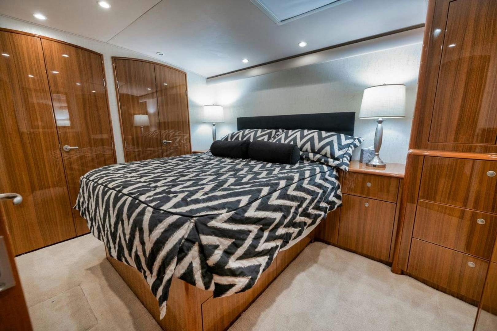 a bedroom with a bed and a wood cabinet aboard 68 VIKING Yacht for Sale