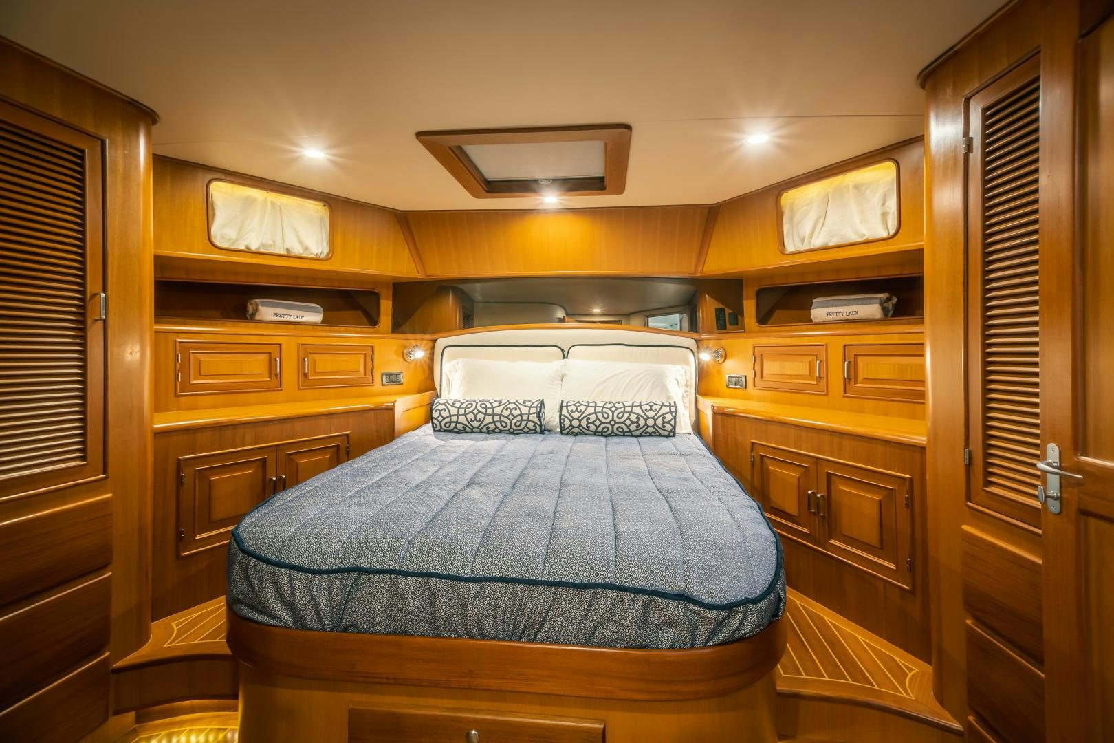 a bedroom with a bed and cabinets aboard PRETTY LADY Yacht for Sale