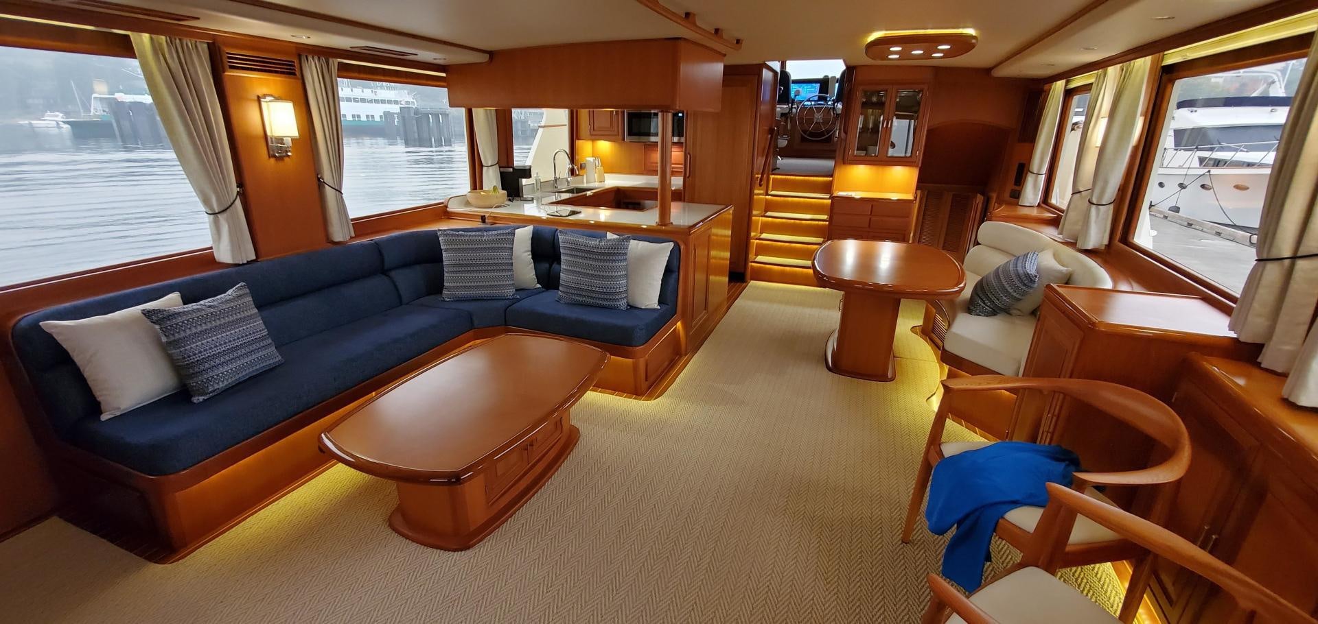 a living room with a blue couch and a table aboard PRETTY LADY Yacht for Sale