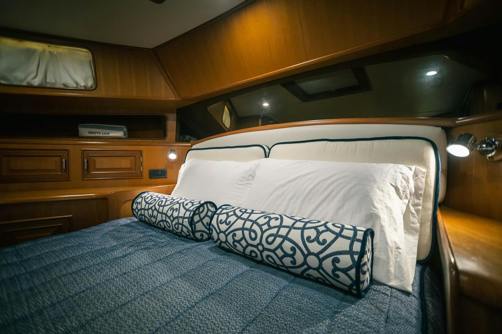 a bed with a blue and white comforter and pillows aboard PRETTY LADY Yacht for Sale