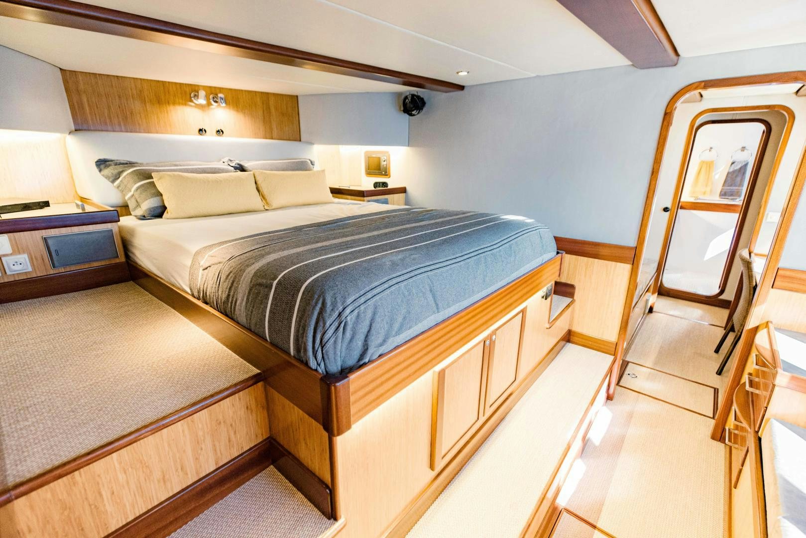 a bedroom with a bed and a mirror aboard IETA Yacht for Sale
