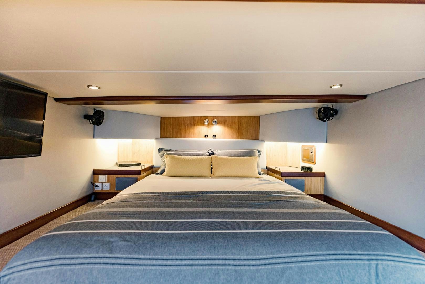 a bed with a blue comforter aboard IETA Yacht for Sale