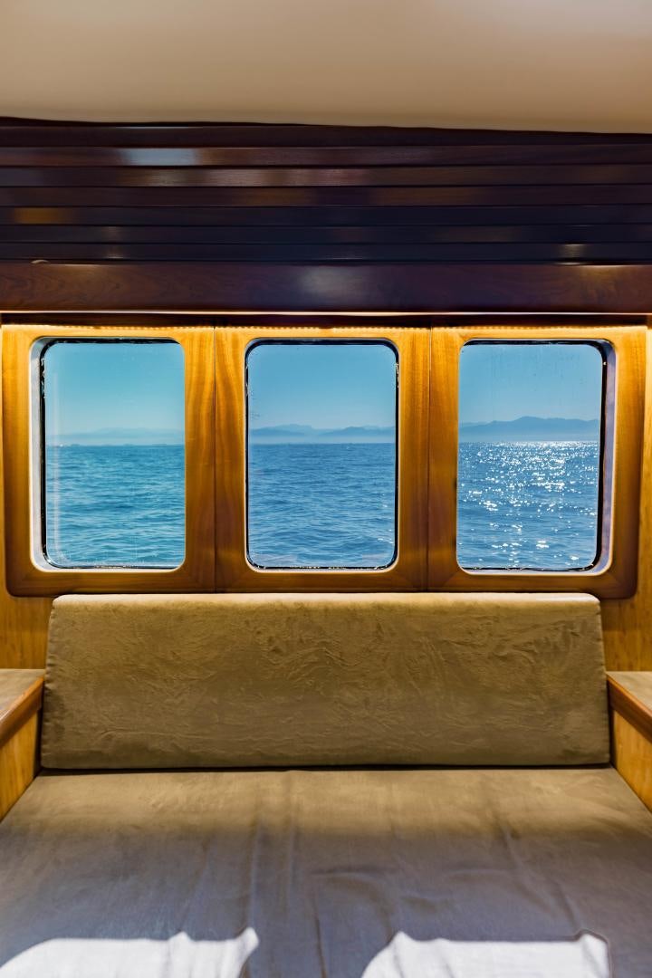 a couch with windows aboard IETA Yacht for Sale