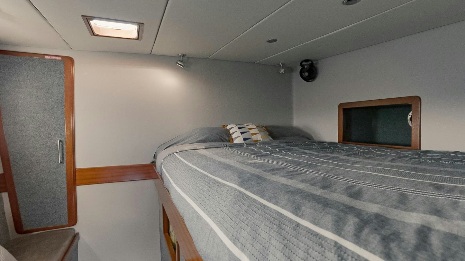 a bed with a television on the wall aboard IETA Yacht for Sale