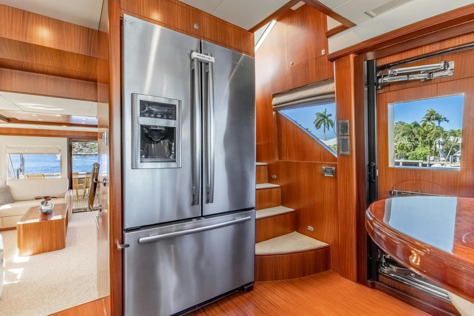 a stainless steel refrigerator in a wooden kitchen aboard JOURNEY Yacht for Sale