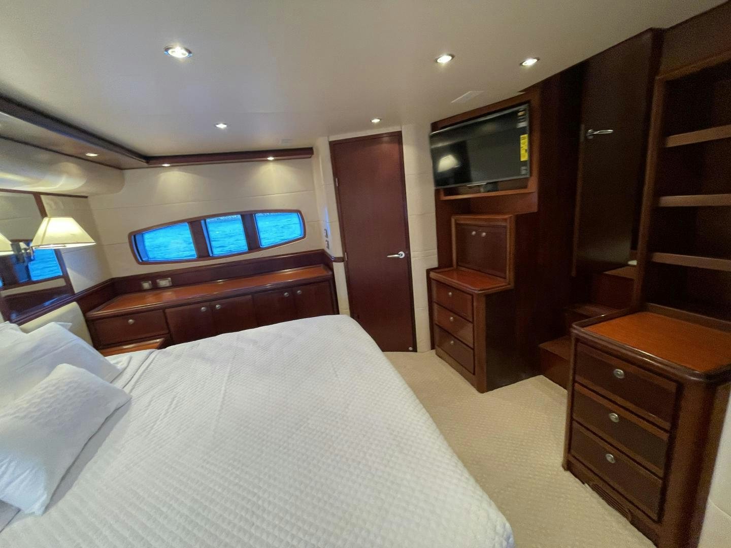 a bedroom with a bed and a tv on the wall aboard ONIX Yacht for Sale