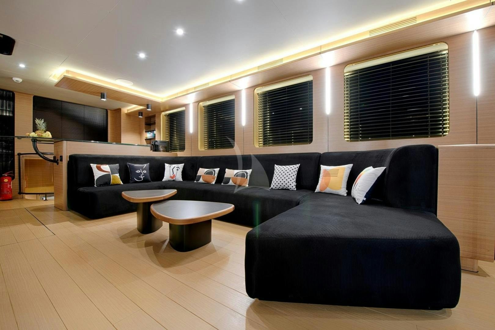 a living room with a black couch and a table aboard MITI ONE Yacht for Sale