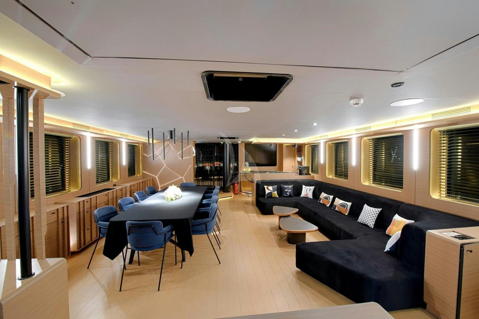 a living room with a large black couch and a large tv aboard MITI ONE Yacht for Sale