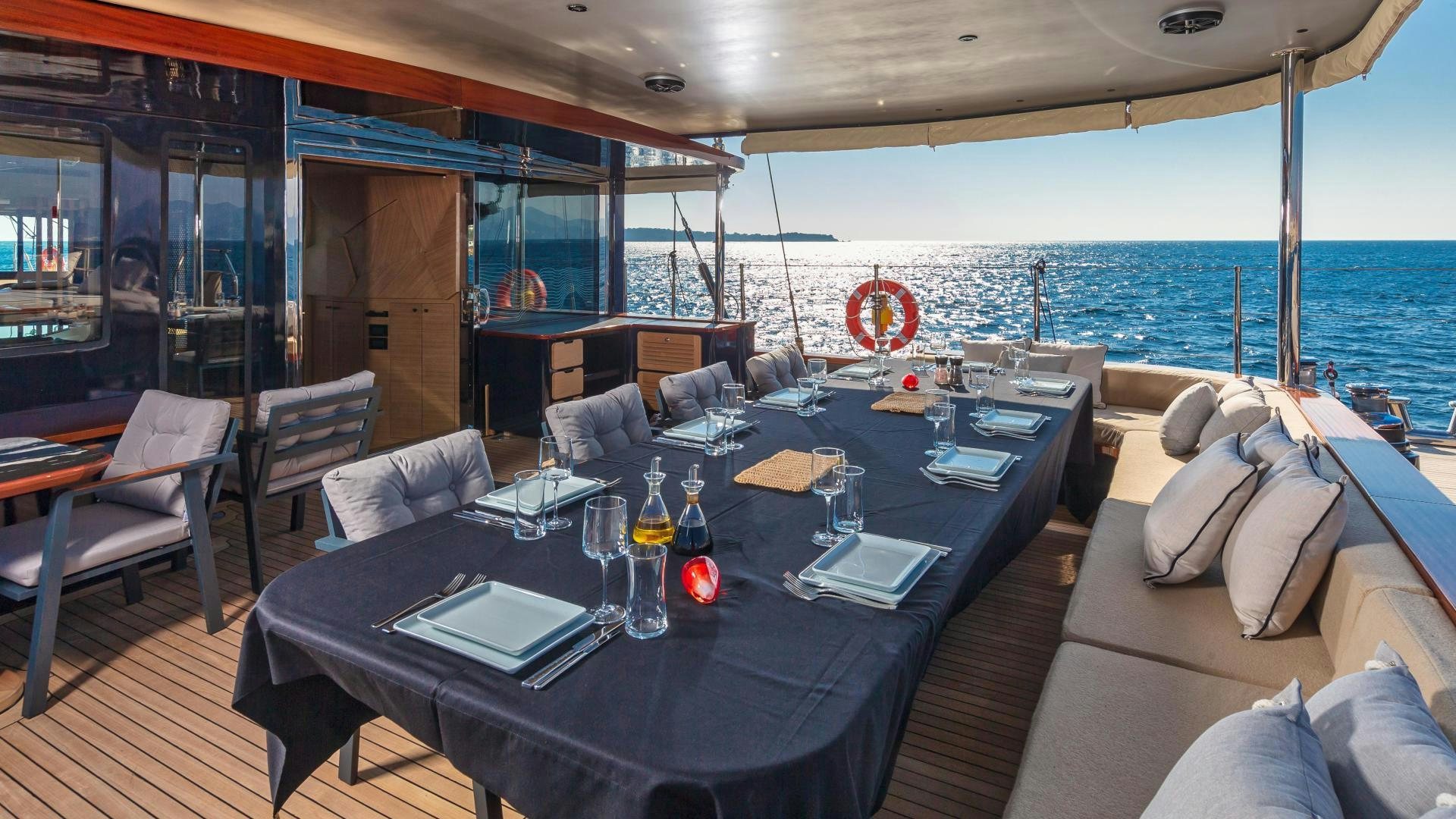a large table with a glass of wine on it aboard MITI ONE Yacht for Sale