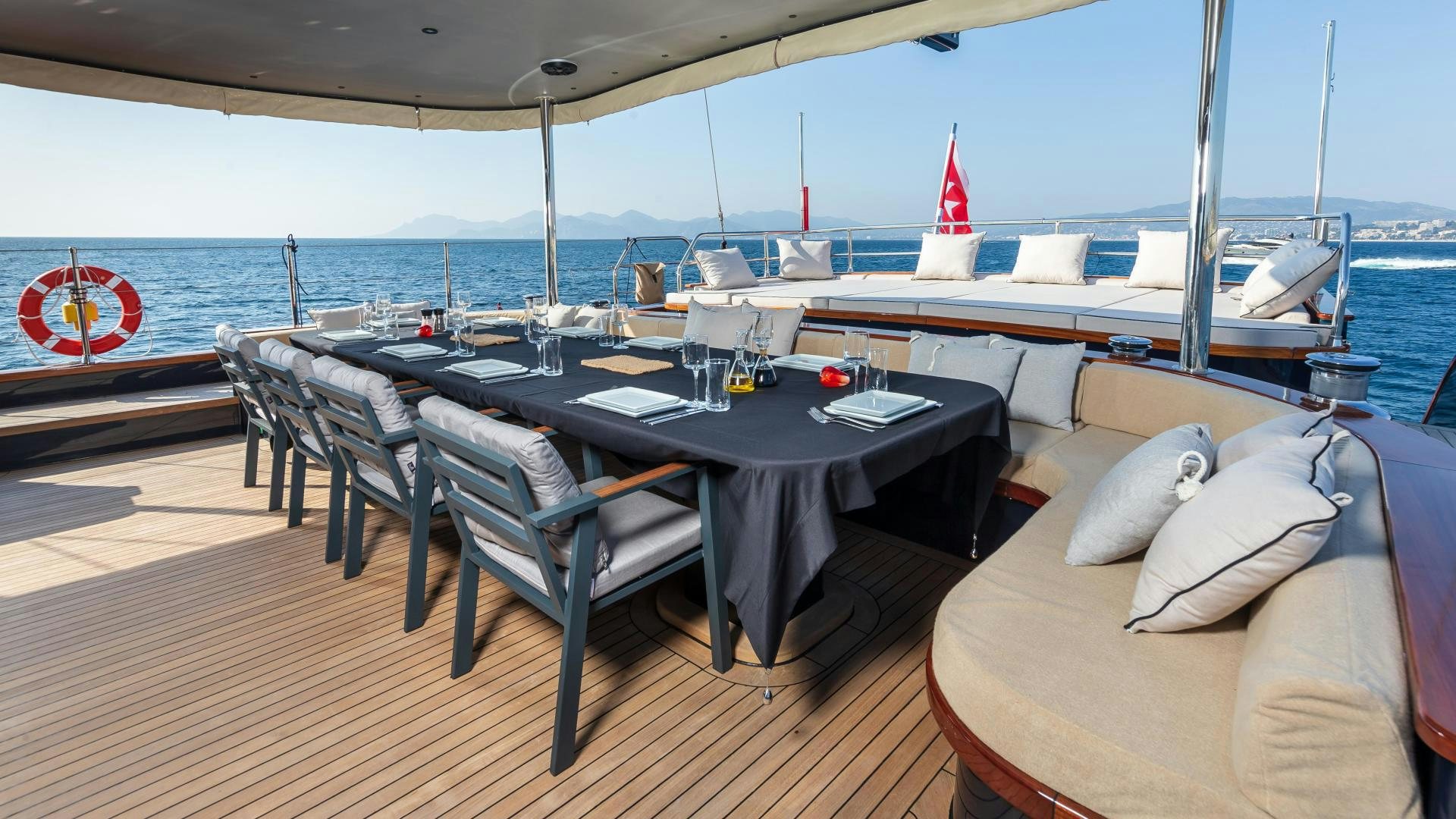 a table with chairs on a deck overlooking a large body of water aboard MITI ONE Yacht for Sale