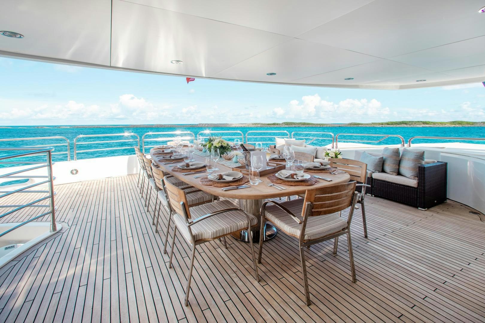 a dining table on a deck overlooking the ocean aboard ACACIA Yacht for Sale