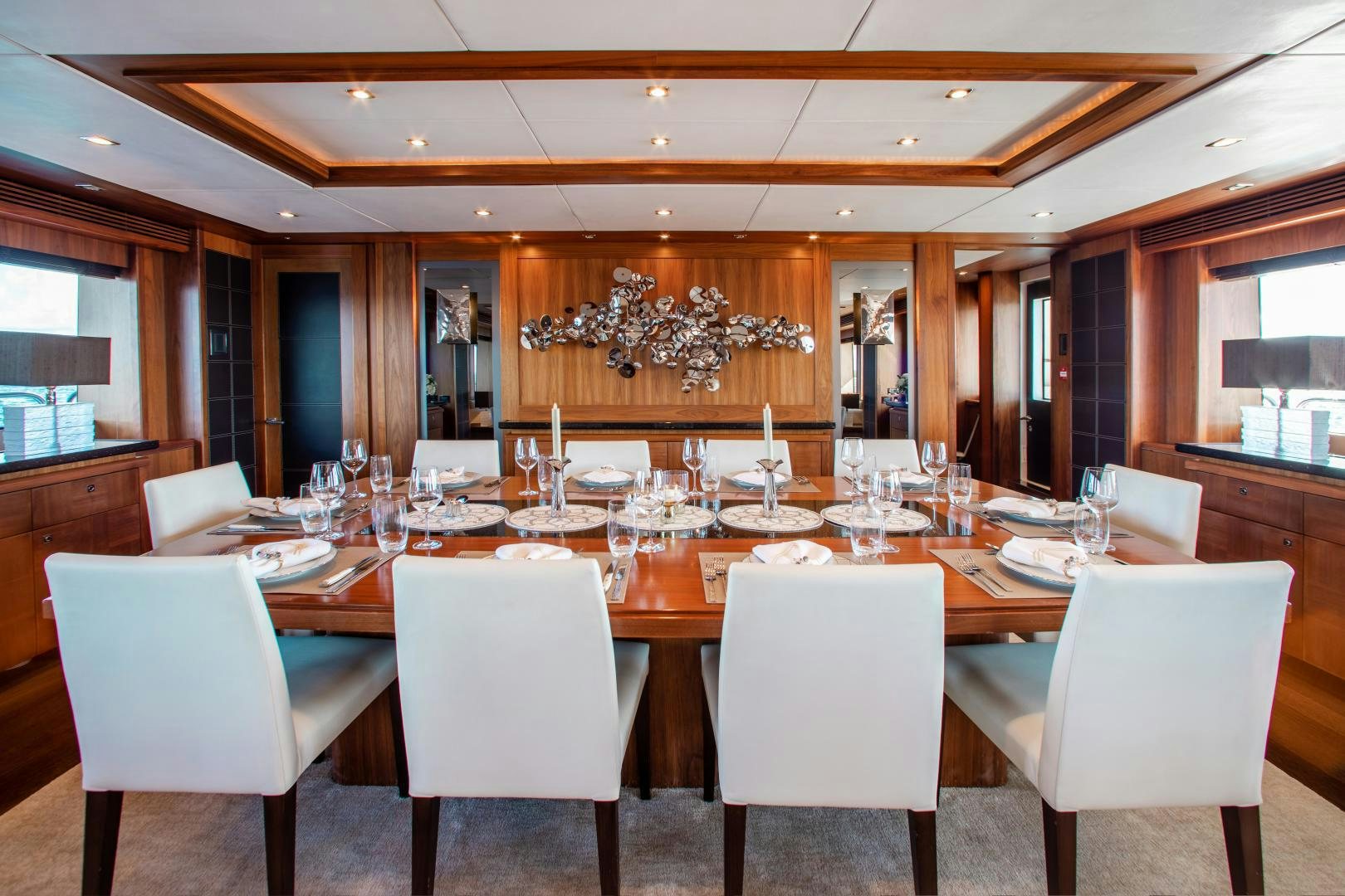 a large dining table with white chairs aboard ACACIA Yacht for Sale