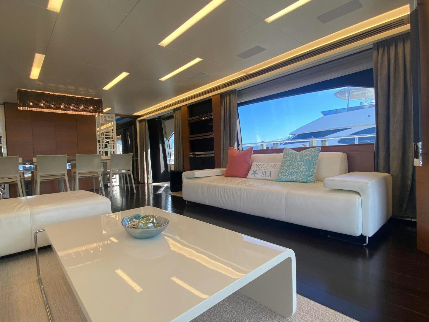 a room with a couch and a table and a large window aboard LA TACHE Yacht for Sale