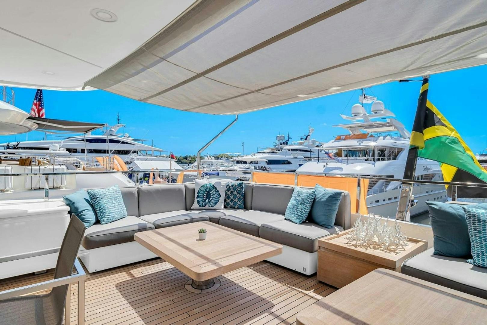 a large lounge area with a large blue and white striped lounge chair and a large white lounge chair aboard AWAY Yacht for Charter