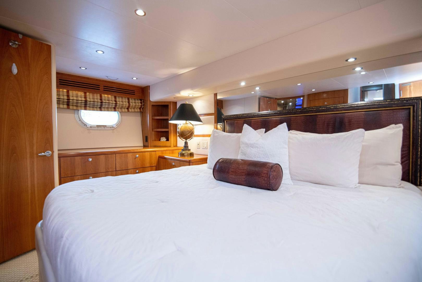 a bed with pillows and a lamp aboard IONA LOUISE Yacht for Sale