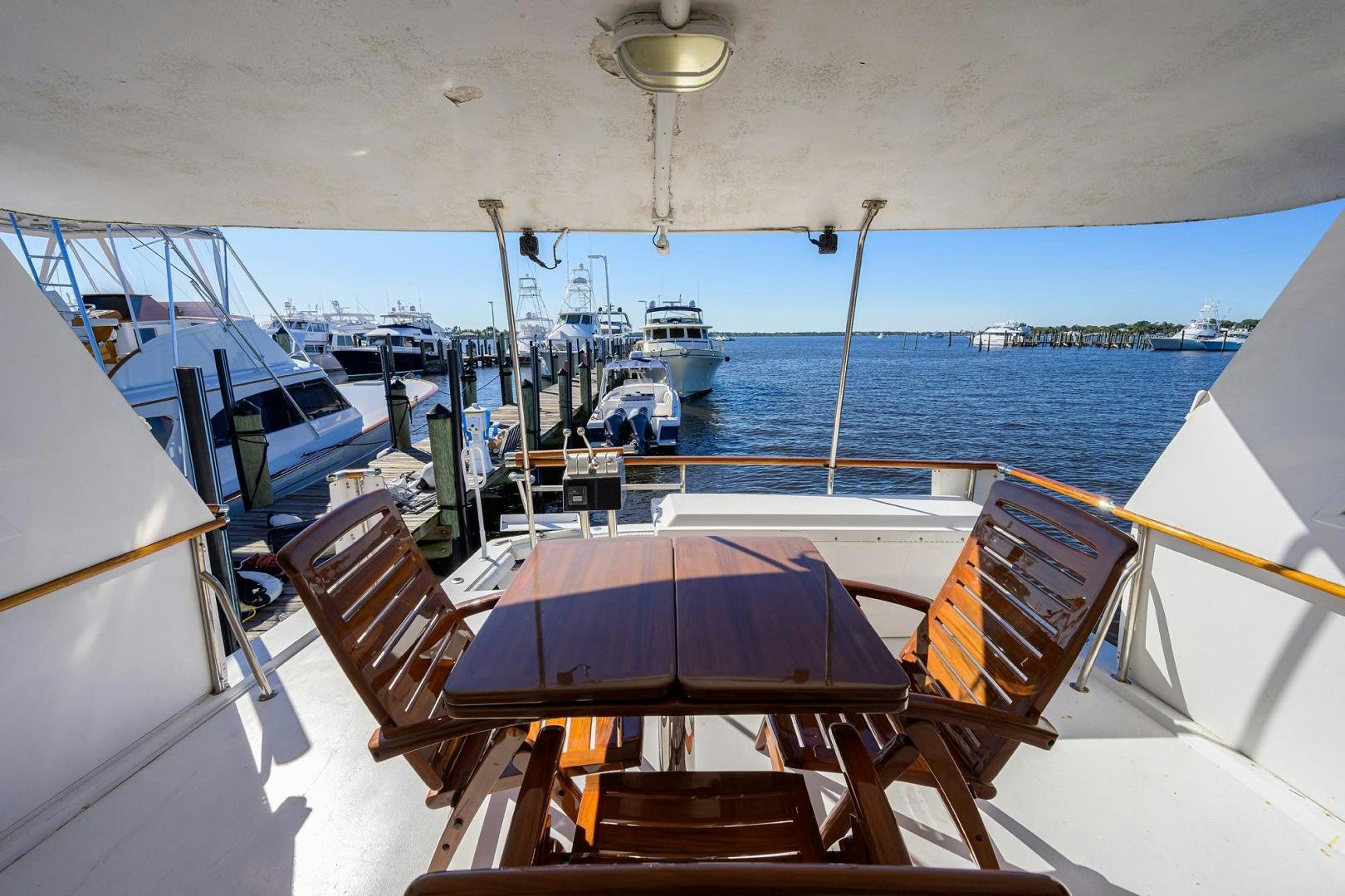a deck with a table and chairs on it and boats in the water aboard CHRISTIE LEE Yacht for Sale