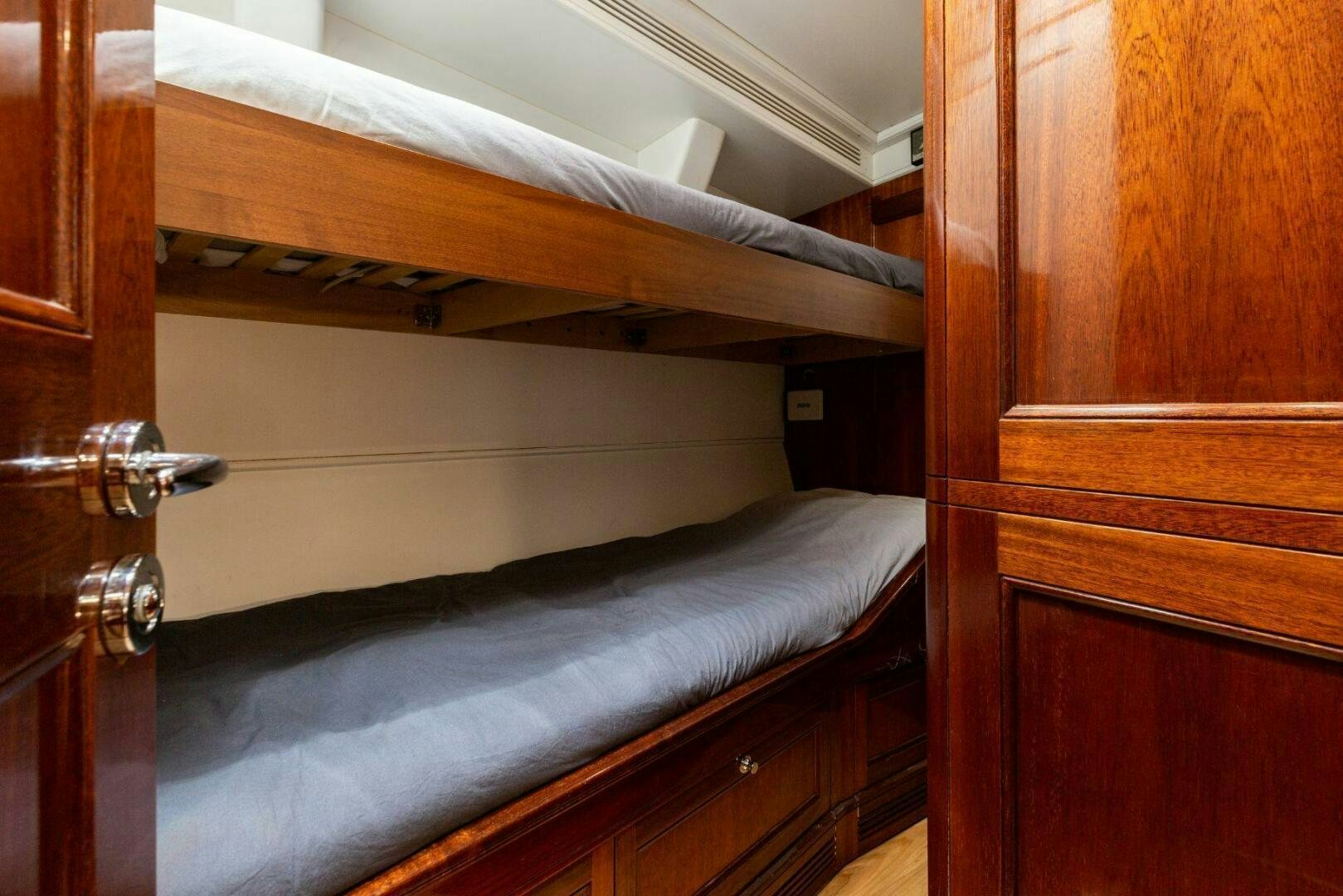 a bed with a wooden headboard aboard GWEILO Yacht for Sale