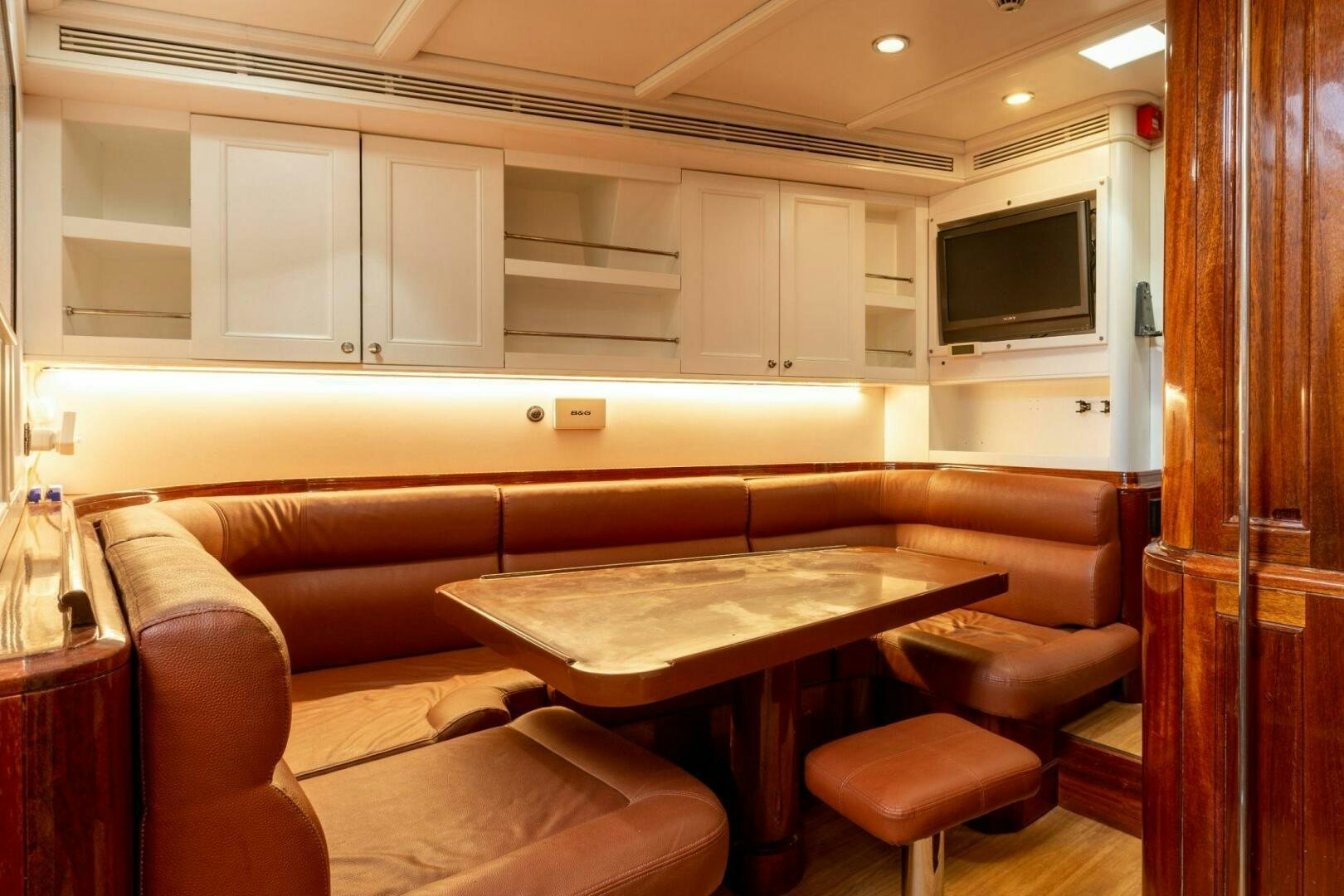 a room with a table and couch aboard GWEILO Yacht for Sale