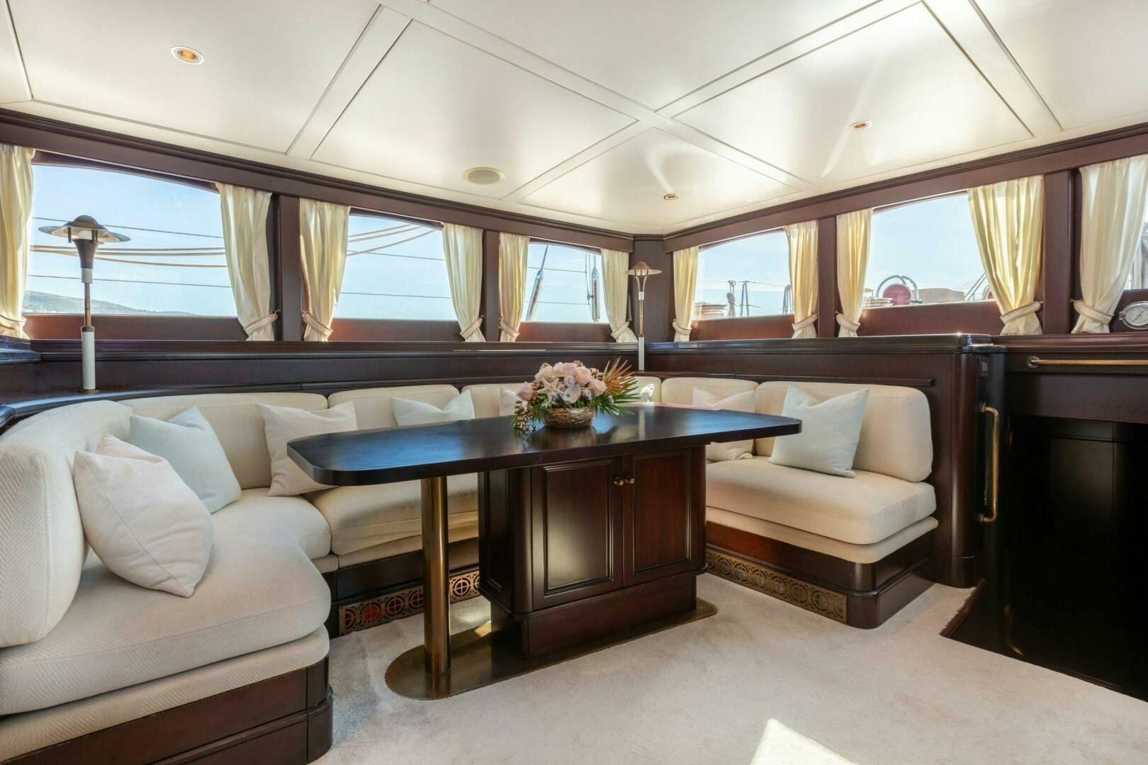 a living room with a table and couches aboard GWEILO Yacht for Sale