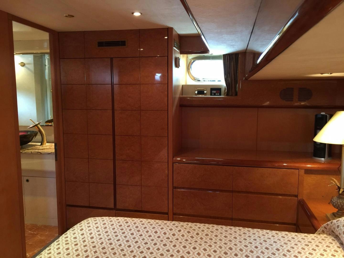 a room with a bed and a wood cabinet aboard UNZIPPED Yacht for Sale