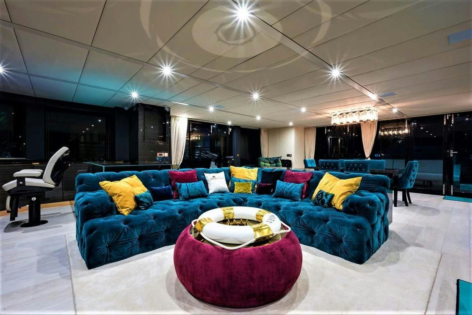 a large living room with a blue couch and white pillows aboard ROCK STAR 2.0 Yacht for Sale