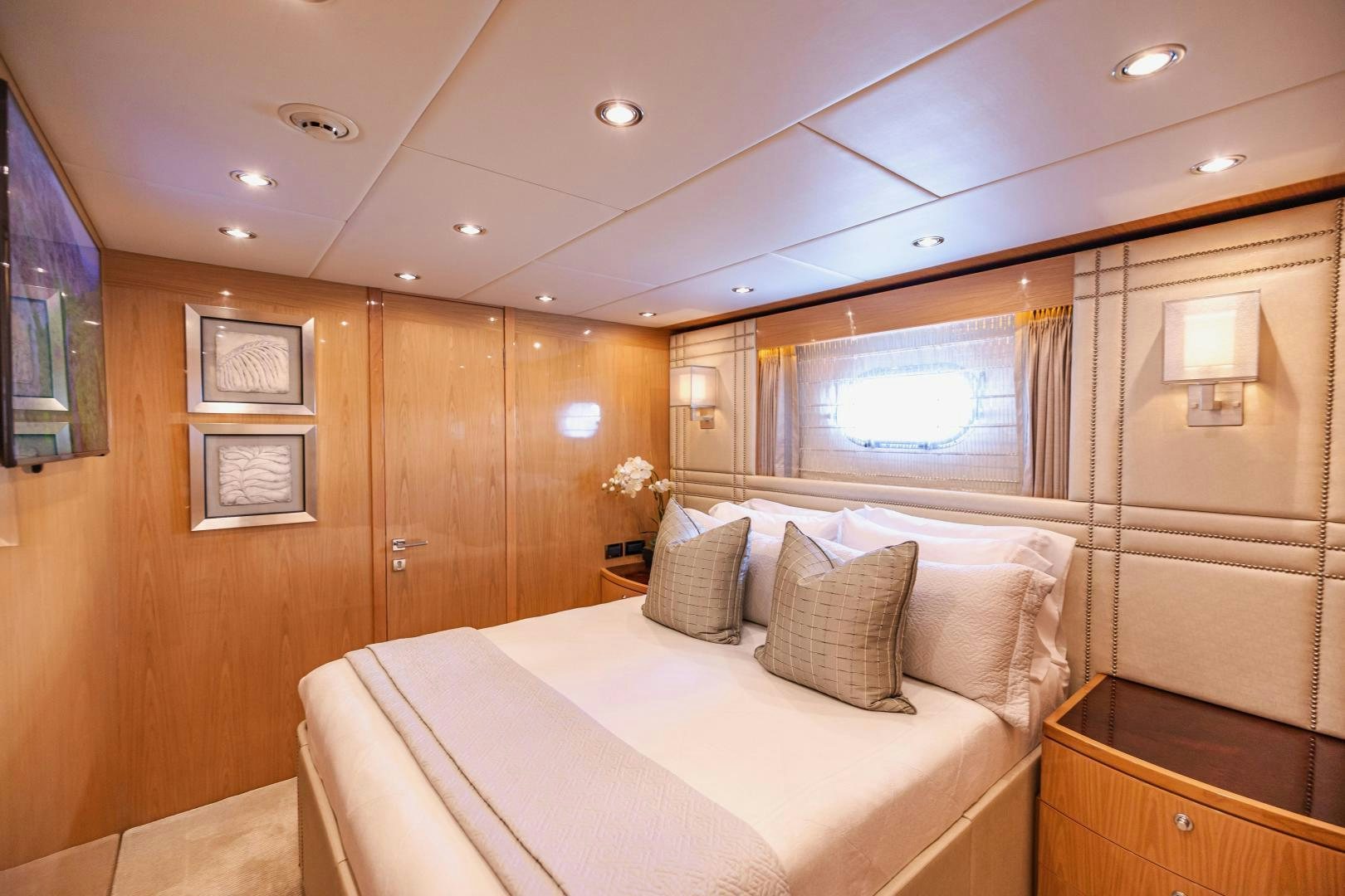 a bedroom with a bed and a wood cabinet aboard GRATITUDE Yacht for Sale