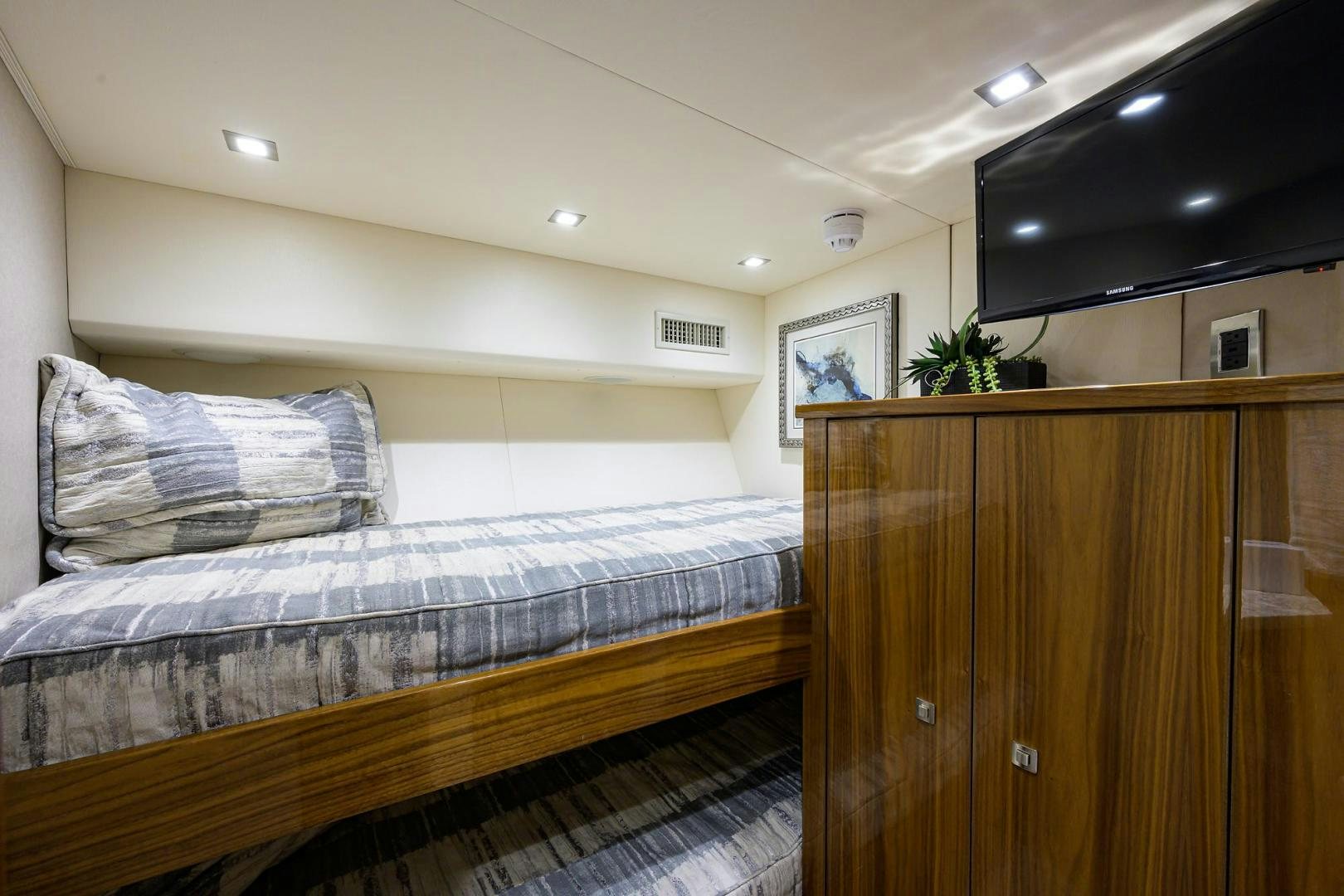 a bedroom with a bed and a wood cabinet aboard QUICK RAISE Yacht for Sale