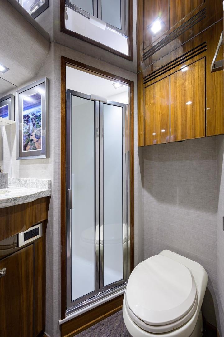 a bathroom with a toilet and wooden cabinets aboard QUICK RAISE Yacht for Sale