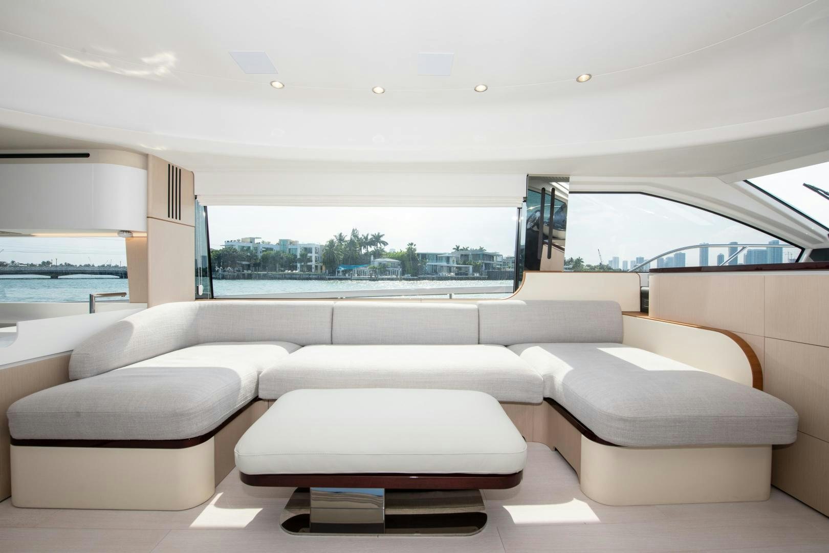 a white living room with a large window and a view of the water aboard CRIMSON Yacht for Sale