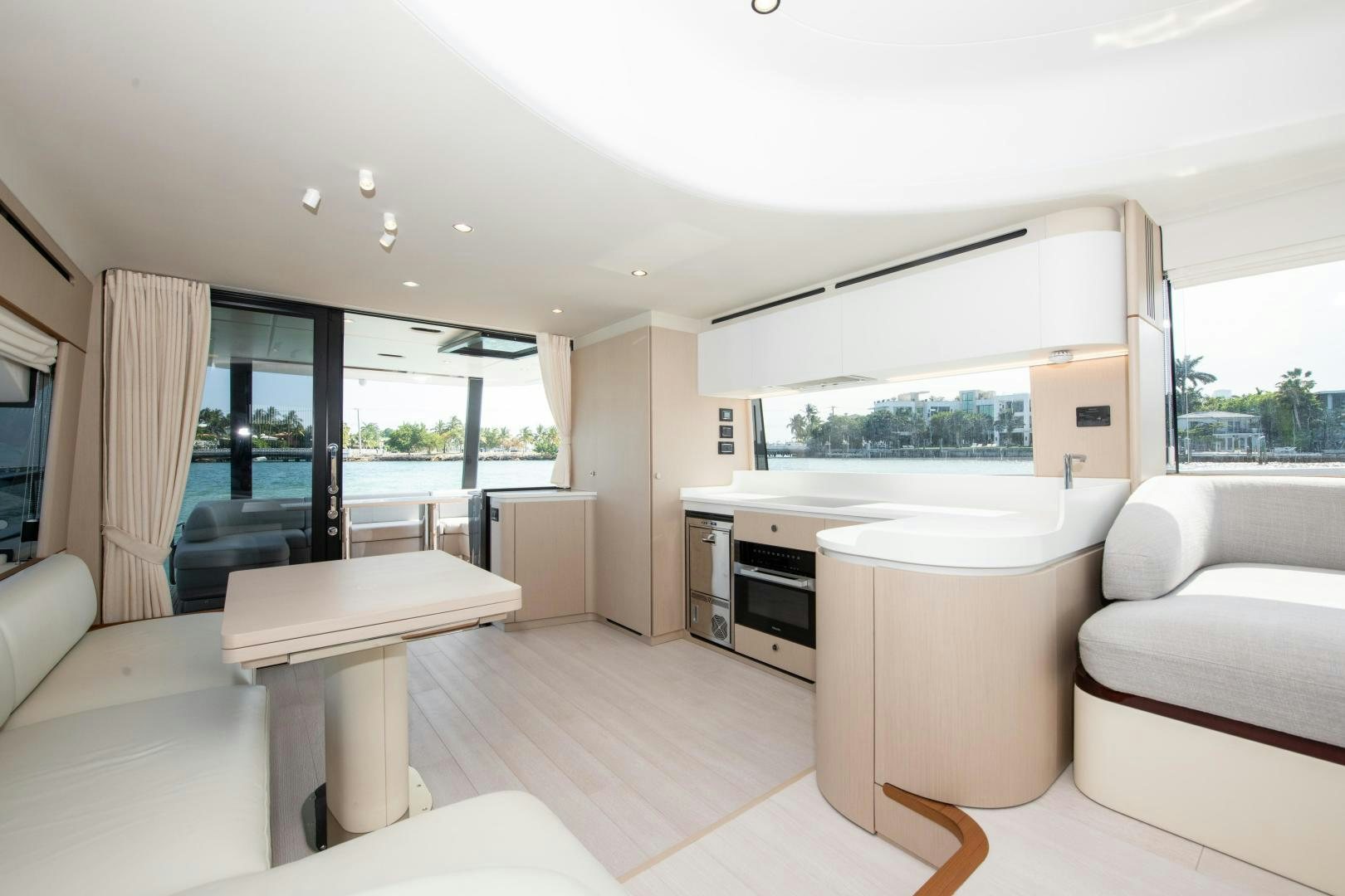 a living room with a kitchen and a dining table aboard CRIMSON Yacht for Sale