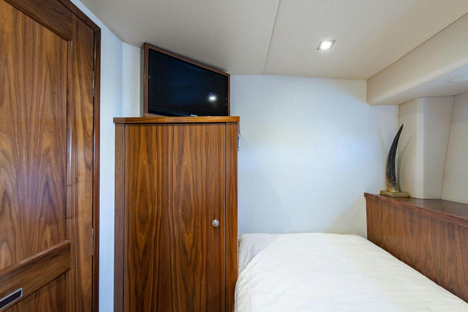 a bedroom with a tv on the wall aboard OBSESSION Yacht for Sale