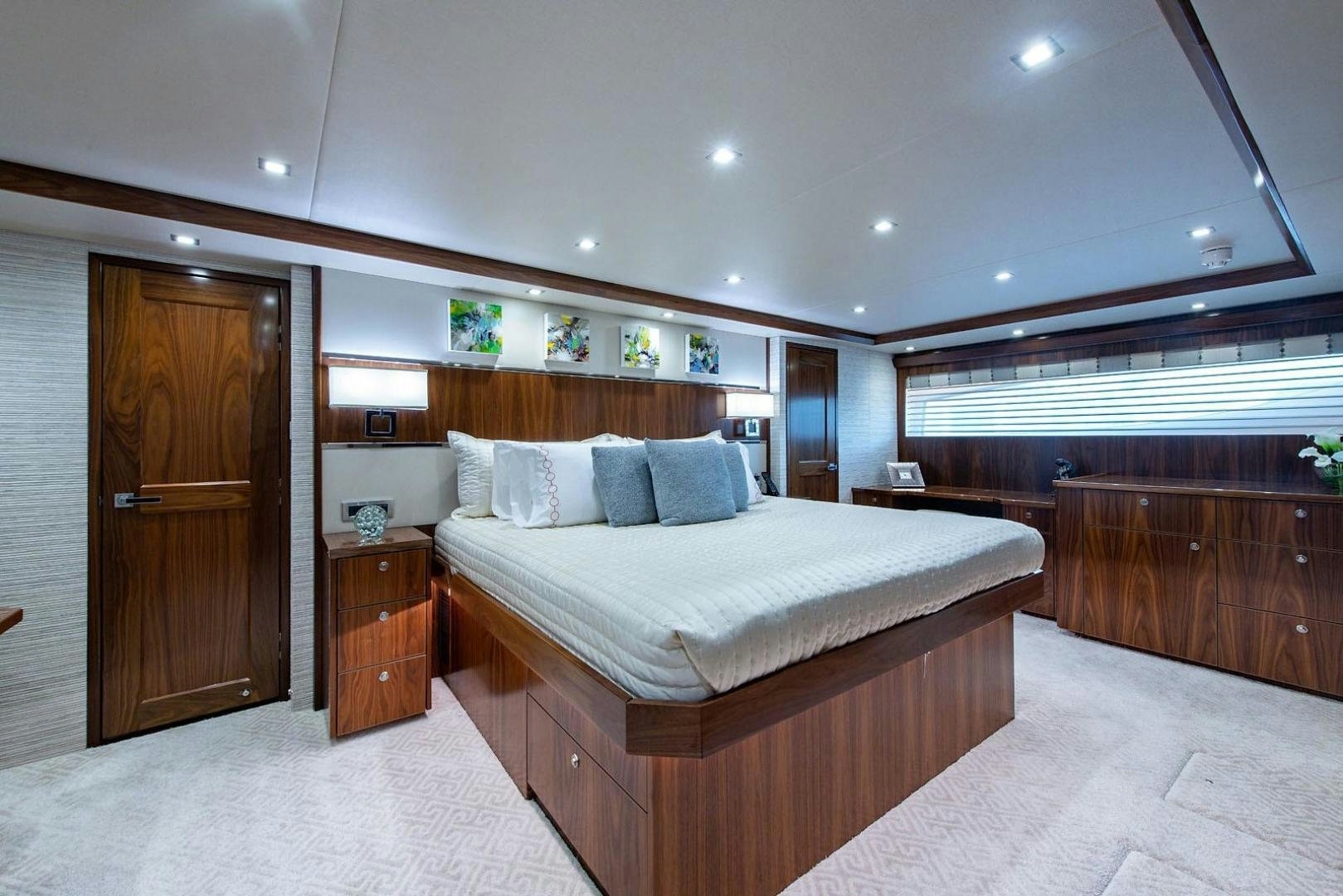 a bedroom with a bed and a wood door aboard OBSESSION Yacht for Sale