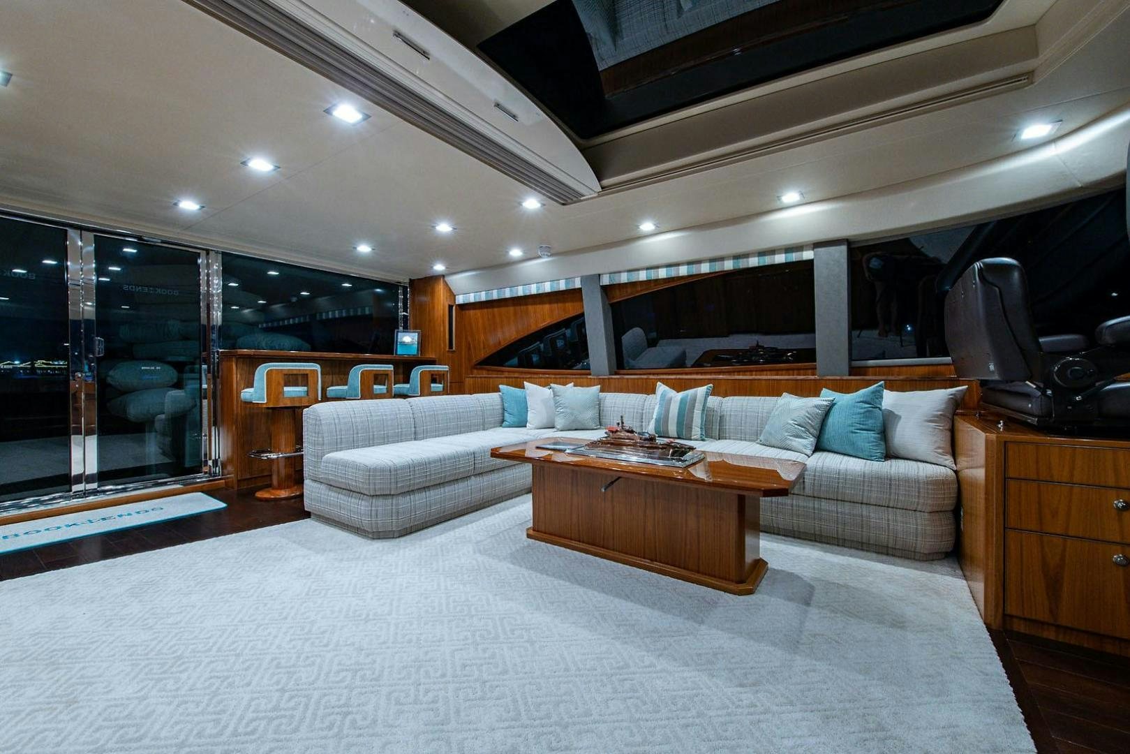 a living room with a large white rug and a wood coffee table aboard OBSESSION Yacht for Sale
