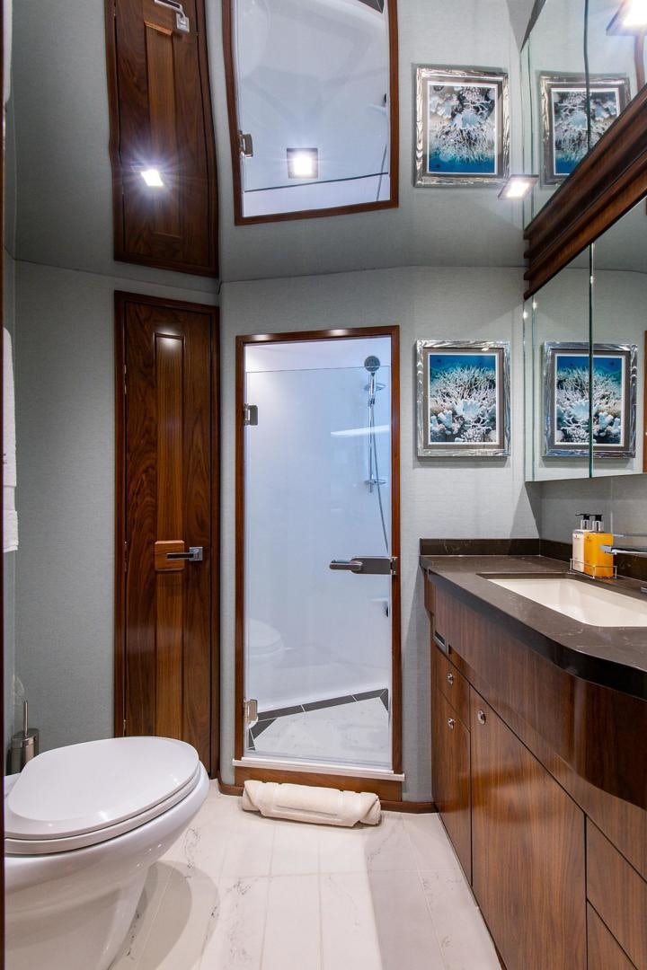 a bathroom with a glass shower door aboard OBSESSION Yacht for Sale