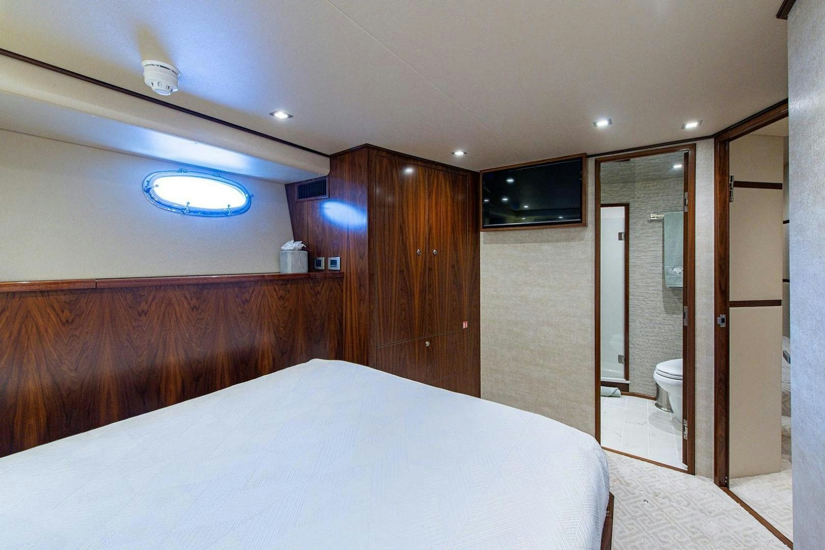 a bedroom with a bed and a closet aboard OBSESSION Yacht for Sale