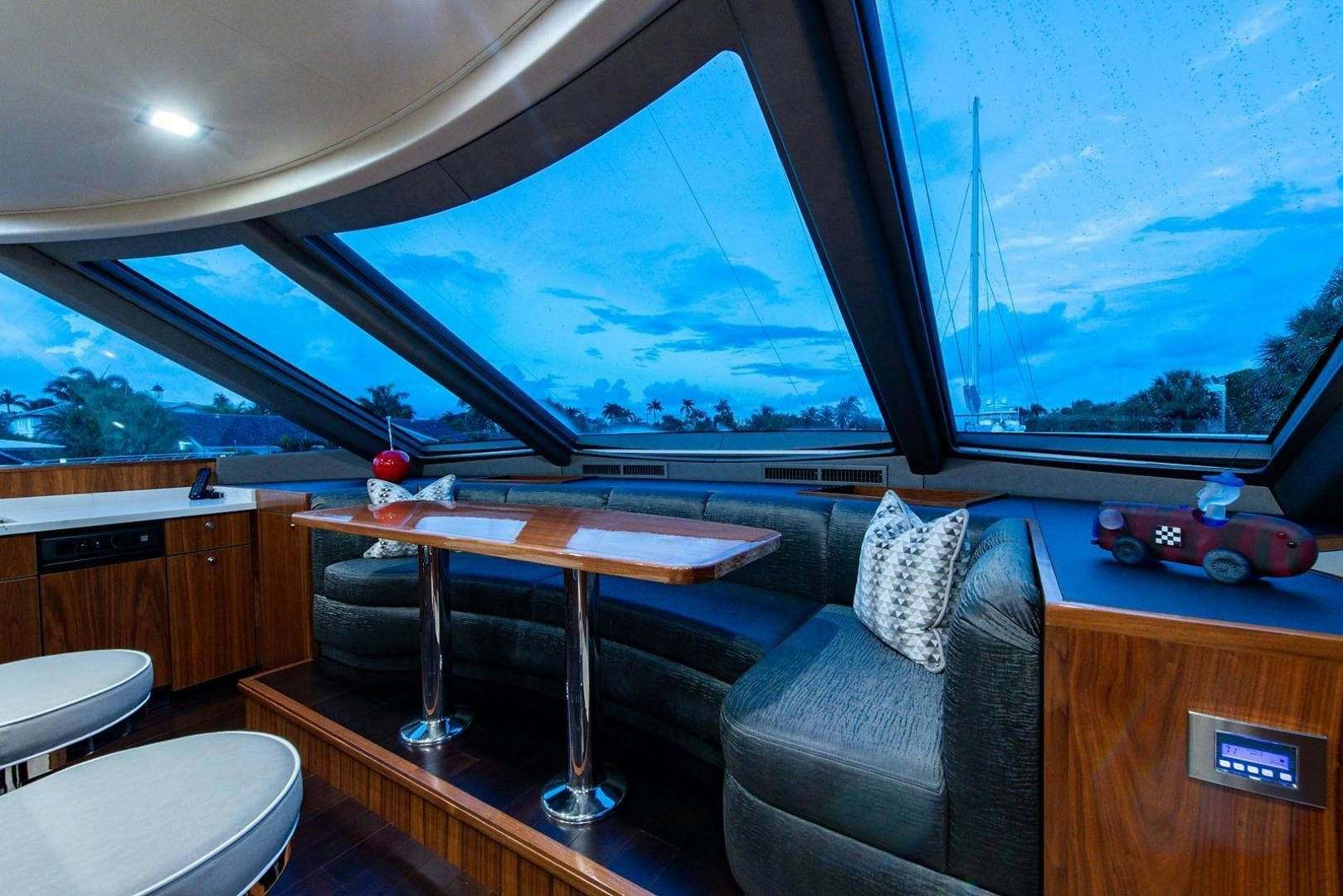 a room with a table and a window with a view of the mountains aboard OBSESSION Yacht for Sale