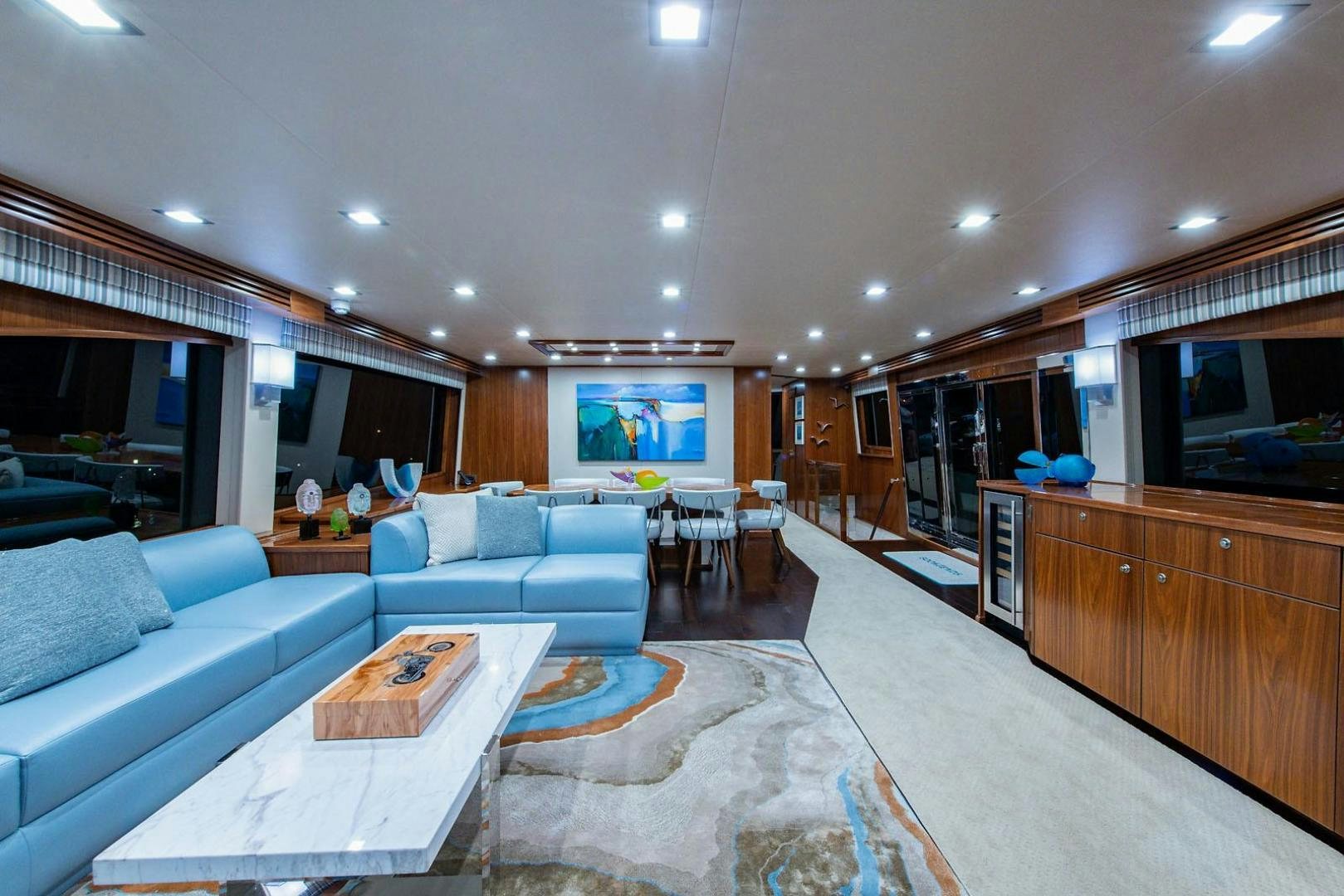 a living room with a kitchen and dining area aboard OBSESSION Yacht for Sale