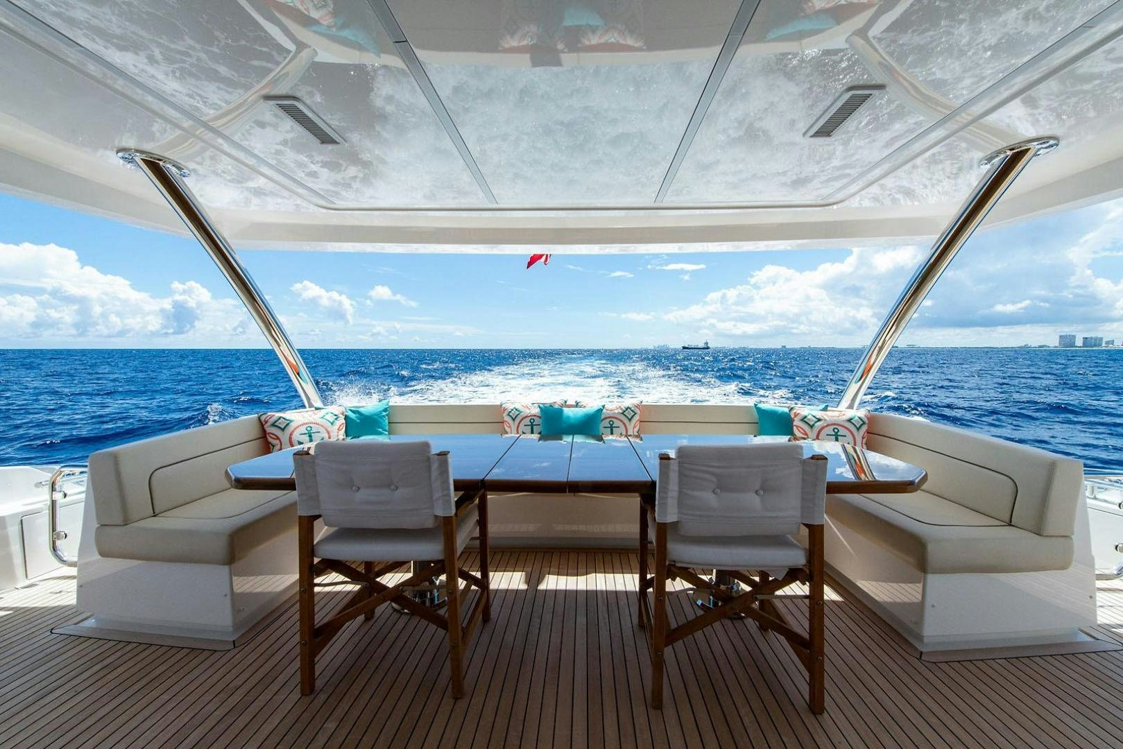 a table and chairs on a deck overlooking the ocean aboard OBSESSION Yacht for Sale
