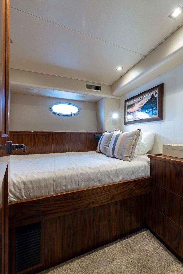 a bed with a white comforter aboard OBSESSION Yacht for Sale